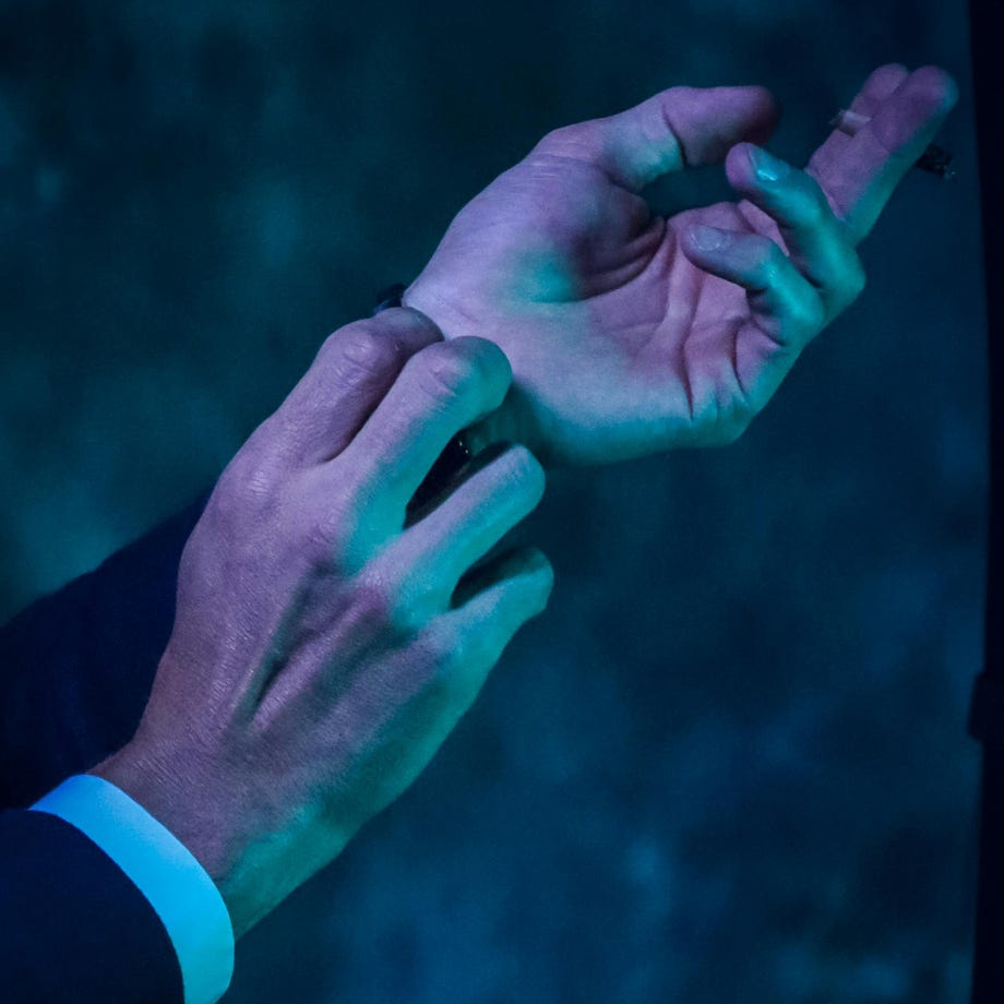A man in a suit and tie is holding his hand